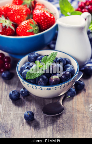 Beeren in Schalen auf hölzernen Hintergrund. Erdbeeren, Himbeeren und Heidelbeeren. Gesundheit, Ernährung, Gartenbau, Ernte-Konzept Stockfoto