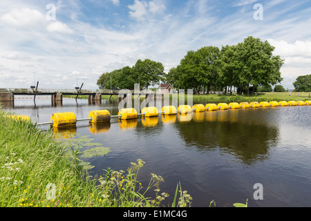 Flut in niederländischen Fluss Vecht mit einem schwimmenden gelben Barrikade Stockfoto