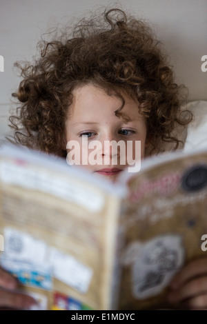 Mädchen-Lesebuch im Bett Stockfoto