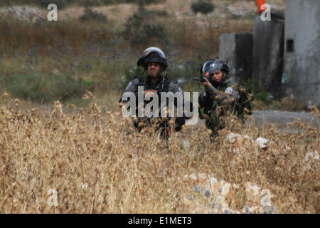 Ramallah, Palästina. 6. Juni 2014. Ramallah, Westjordanland, Palästina: Eine israelische Soldatin Gummigeschosse abgefeuert während der Demonstration in Solidarität mit den palästinensischen Gefangenen in israelischen Gefängnissen, im Westjordanland-Dorf von Nabi Saleh, in der Nähe von Ramallah am 6. Juni 2014. Mehr als 120 Palästinenser ohne Prozess in Israel wurden auf einen unbefristeten Hungerstreik im Gefängnis, nur Salz essen und trinken Wasser, seit dem 24. April, fordern ein Ende der sogenannten "Administrativhaft" Credit: Abdalkarim Museitef/NurPhoto/ZUMAPRESS.com/Alamy Live News Stockfoto