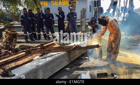 US Navy Konstruktionsmechaniker 2. Klasse Nate Emmett, rechts, mit Unterwasser Bau Team 2, erklärt exotherme schneiden Stockfoto