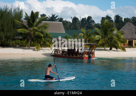 Aitutaki. Cook Island. Polynesien. Süd-Pazifik. Ein Tourist praktiziert Rudern neben dem Strand Aitutaki Lagoon Resort & Stockfoto