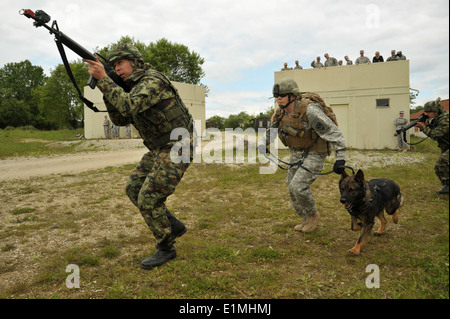 US Secretary Of The Army John M. McHugh, Dritter von rechts, oben beobachtet, wie ein US-Soldat, zentrieren, Züge mit serbischen Soldaten Stockfoto