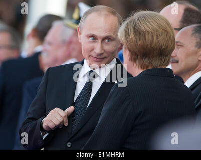 Ouistreham, Frankreich. 6. Juni 2014. Deutsche Bundeskanzlerin Angela Merkel (CDU) spricht mit Russlands Präsidenten Vladimir Putin anlässlich des 70. Jahrestags der Landungstruppen der Alliierten in der Normandie in Ouistreham, Frankreich, 6. Juni 2014. Foto: Michael Kappeler/Dpa/Alamy Live News Stockfoto