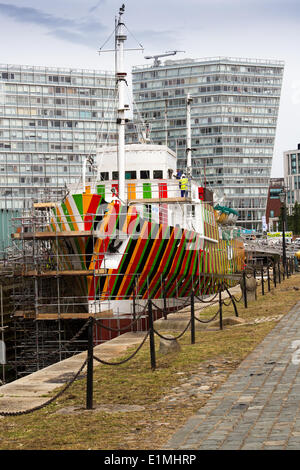 Liverpool Pilot Cutter Nummer 2, 1953 der Edmund Gardner wird durch getarnte rote, schwarze, orange & grüne Streifen,‘„Razzle Dazzle Dazzle“ gemaltes Kriegsdesign verwandelt. Der renommierte Künstler Carlos Cruz-Diez, der alle zwei Jahre lebt, wurde beauftragt, mit „Dazzle“-Tarnung eines historischen Pilotschiffs zu arbeiten, das im Besitz des Merseyside Maritime Museum ist und dessen Besitz es ist. Das Schiff, das sich im Trockendock neben Liverpools Albert Dock befindet, wird von dem Team Cammell Laird bemalt, um das Kriegsdesign zu realisieren. Stockfoto