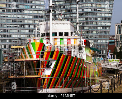 Liverpool Pilot Cutter Nummer 2, 1953 der Edmund Gardner wird durch getarnte rote, schwarze, orange & grüne Streifen,‘„Razzle Dazzle Dazzle“ gemaltes Kriegsdesign verwandelt. Der renommierte Künstler Carlos Cruz-Diez, der alle zwei Jahre lebt, wurde beauftragt, mit „Dazzle“-Tarnung eines historischen Pilotschiffs zu arbeiten, das im Besitz des Merseyside Maritime Museum ist und dessen Besitz es ist. Das Schiff, das sich im Trockendock neben Liverpools Albert Dock befindet, wird von dem Team Cammell Laird bemalt, um das Kriegsdesign zu realisieren. Stockfoto