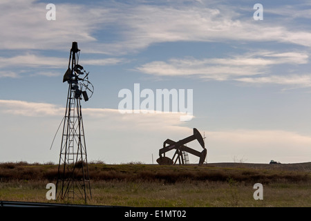 Watford Stadt, North Dakota - Öl wird in der Nähe einer alten Farm Windmühle in der Bakken Shale Formation gepumpt. Stockfoto