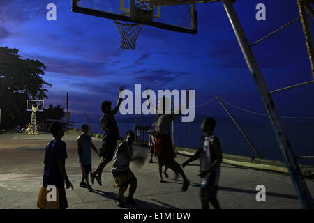 Dumaguete, Negros Oriental, Philippinen. 4. Juni 2014. Anwohner spielen auf in die Dunkelheit 4. Juni 2014, bei einem Basketballplatz am Meer in Dumaguete City auf der Insel Negros in den Philippinen. PHILLIP PRINS © Phillip Prins/Prensa Internacional/ZUMAPRESS.com/Alamy Live-Nachrichten Stockfoto