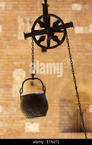 Siena, Provinz Siena, Toskana, Italien. Eimer über Brunnen im Innenhof des Palazzo Chigi Saracini. Stockfoto