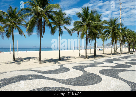 Kultige Bürgersteig Fliesenmuster mit Palmen am Copacabana Strand Rio de Janeiro Brasilien Stockfoto