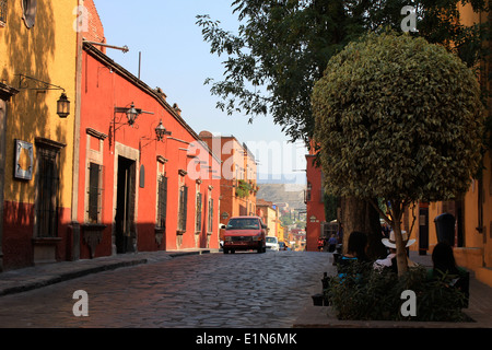 Auf der Suche auf einer gepflasterten Straße, gesäumt von bunten Häusern in San Miguel de Allende, Guanajuato, Mexiko / Calle de San Miguel Stockfoto