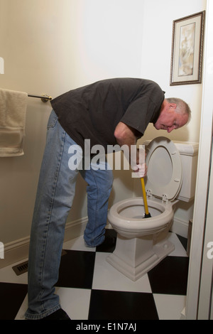 Mann mit Kolben Befestigung verstopfte Toilette Stockfoto