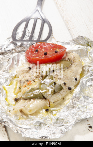 gebackener Pangasius mit Paprika und Tomaten in Alufolie Stockfoto