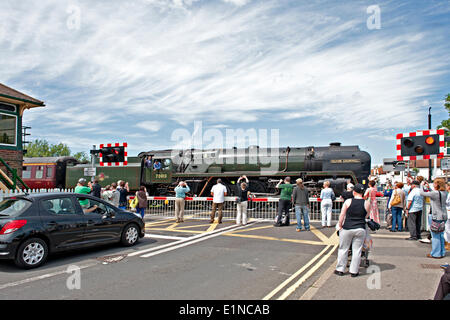 Polegate, East Sussex, UK. 7. Juni 2014. Ein Sonderzug, laufen, feiern 150 Jahre Seaford Brighton railway übergeht Straßenkreuzung bei Polegate auf der Linie zwischen Eastbourne und Lewes, beobachtet von Massen zu bewundern. Der Zug, der Brighton, Eastbourne, Seaford und Newhaven Harbour besucht wurde durch die erhaltene Lokomotive, Brittania Klasse 70013 geschleppt "Oliver Cromwell". Diese Lokomotive zog der letzte Dampfzug der British Railways im Jahr 1968, und kann oft auf der Hauptstrecke seit Erhalt gesehen werden. Bildnachweis: Patrick Nairne/Alamy Live-Nachrichten Stockfoto