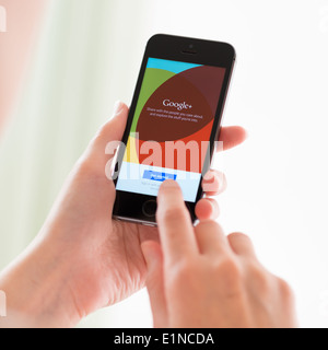 Person, die eine brandneue Apple iPhone 5 s mit Google +-Anwendung auf einem Bildschirm Stockfoto