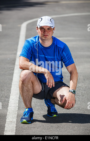Junge männliche Läufer Vorbereitungen zu beginnen. Stockfoto