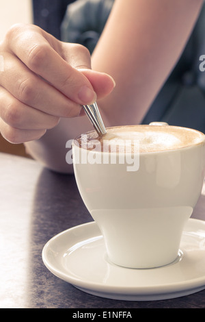 Kaffee am Morgen. Tasse Cappuccino im Cafe. Mädchen Verkostung Creme Stockfoto