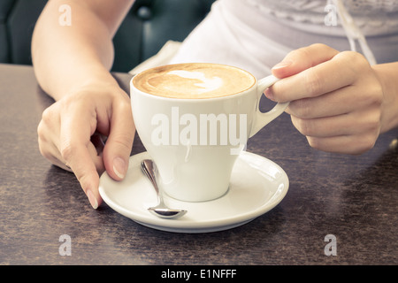 Kaffee am Morgen. Tasse Cappuccino im Cafe. Warme Farbe getönt Bild Stockfoto