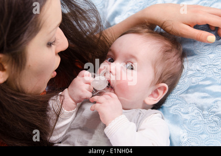 Mutter und Tochter sechs Monate liegen gerne auf der couch Stockfoto