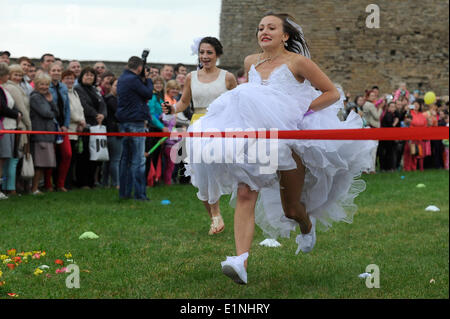 Narva, Estland. 7. Juni 2014. Frauen in Brautkleidern konkurrieren in einem jährlichen Runaway Brides-Wettbewerb in Narva, Estland, 7. Juni 2014. Insgesamt 73 verheiratet und single Frauen aus Estland und Rußland verkleidet als Bräute, die auf einem 50 Meter langen Grass Track hier am Samstag raste. Bildnachweis: Sergei Stepanov/Xinhua/Alamy Live-Nachrichten Stockfoto