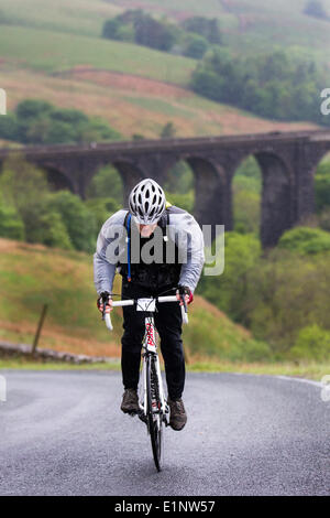 Bergsteigen für Radfahrer in Clapham, Yorkshire, Großbritannien. Juni 2014. Die Fahrer trotzen schlechtem Wetter und fahren während des Open Wheel West Riding Classic 33, 60 & 75 Mile sportlich auf Yorkshire's berühmtesten Straßen und Anstiegen in wunderschöner Landschaft durch den Arten Gill. Eine nicht wettbewerbsfähige Radtour über die wunderschönen Hügel und Täler der Yorkshire Dales. Stockfoto