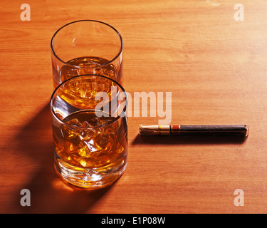 Whiskey Longdrinkglas mit Eis und Zigarre auf hölzernen Hintergrund. Hautnah. Stockfoto