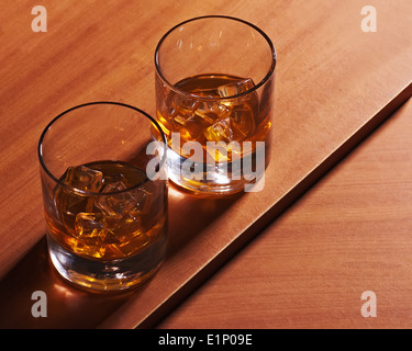 Whiskey Longdrinkglas mit Eis auf hölzernen Hintergrund. Closeup. Stockfoto