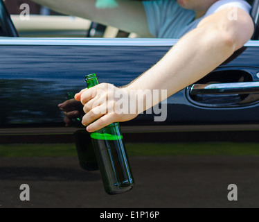 Fahren unter dem Einfluss. Männliche Hand mit Flasche Bier. Stockfoto