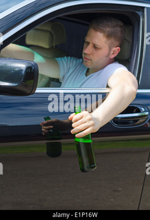 Fahren unter dem Einfluss. Menschen trinken Alkohol im Auto. Stockfoto