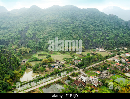 Super Panorama Blick Reis Felder Kalkfelsen und Berggipfel Pagode aus Hang Mua Tempel am frühen regnerischen Morgen Ninh Binh Stockfoto