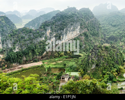 Super Panorama Blick Reis Felder Kalkfelsen und Berggipfel Pagode aus Hang Mua Tempel am frühen regnerischen Morgen Ninh Binh Stockfoto