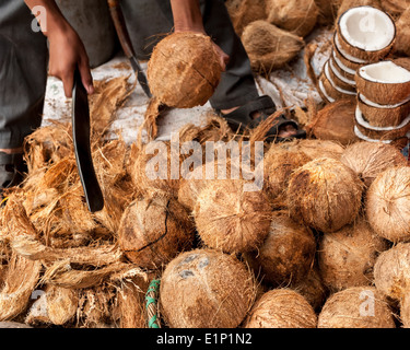 Verkäufer öffnet tropische Kokosnüsse auf traditionelle Speisen Marktplatz Stockfoto