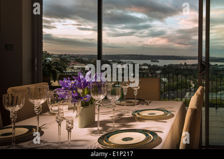 Ein Tisch ausgebreitet auf elegante Weise mit einem schönen Blick auf Sydney Harbour in der Abenddämmerung Stockfoto