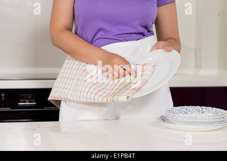 Nahaufnahme von den Händen einer Frau trocknet das Geschirr in der Küche mit einem Geschirrtuch abwischen Stockfoto