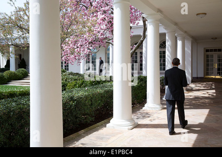 US-Präsident Barack Obama geht entlang der Kolonnade des weißen Hauses vorbei an blühenden Bäumen als Stabschef Denis McDonough 8. April 2014 in Washington, DC auf ihn wartet. Stockfoto