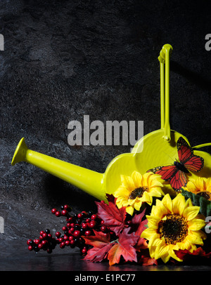 Herbst Einstellung Stillleben mit Vintage-Stil-gelbe Gießkanne und Herbst Blätter, Blumen und Schmetterling Stockfoto