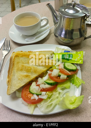 Käse und Zwiebel Toast mit Salat, Tomaten, Gurken und Salat und eine Kanne Tee. Stockfoto