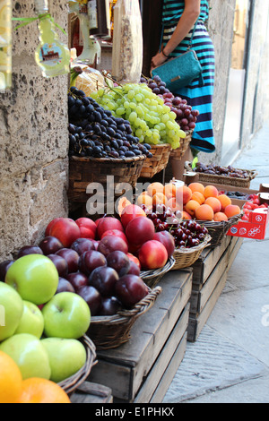 Frischmarkt in den Straßen von Siena, Italien es sind Körbe mit frischem Obst: Äpfel, Trauben, Kirschen, Pflaumen und Pfirsiche. Stockfoto