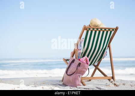 Frau sitzt am Strand im Liegestuhl Stockfoto