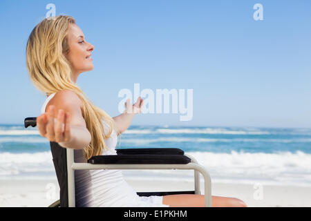 Rollstuhl gebunden blonde lächelnd am Strand Stockfoto