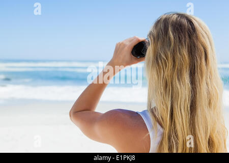 Blick auf den Ozean durch Fernglas Blondine Stockfoto