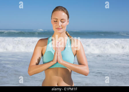 Fit Woman meditieren am Strand Stockfoto