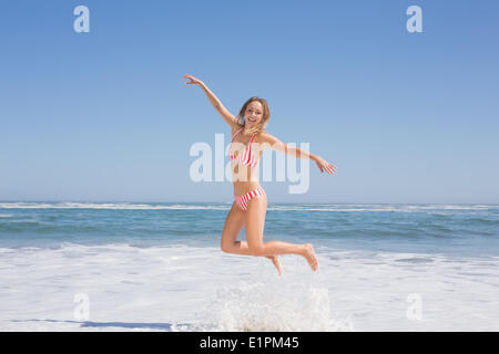 Happy fit Frau im Bikini am Strand springen Stockfoto