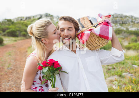 Süßes Paar gehen für ein Picknick mit Frau Freunde Wange küssen Stockfoto