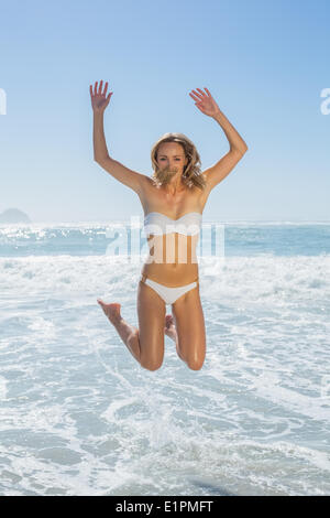 Wunderschöne Blondine in weißen Bikini am Meer springen Stockfoto