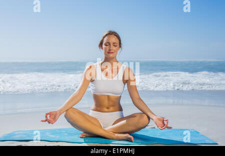 Fit ruhig Frau sitzt in Lotus-Pose am Strand Stockfoto