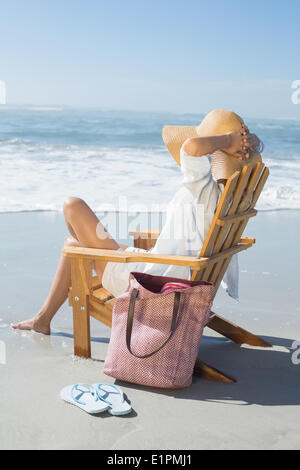 Frau sitzt auf hölzernen Liegestuhl am Meer Stockfoto