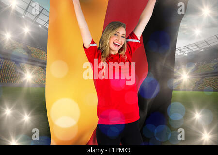 Zusammengesetztes Bild von jubelnden Fußball-Fan in rot mit deutscher Flagge Stockfoto