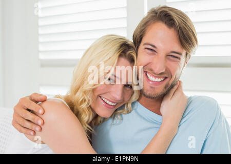 Niedliche casual paar auf Couch Lachen in die Kamera Stockfoto