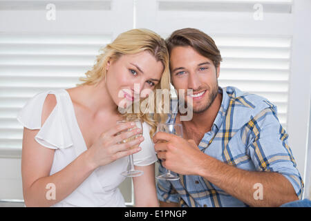 Süße junge Paar sitzt am Boden zusammen mit Weißwein Stockfoto